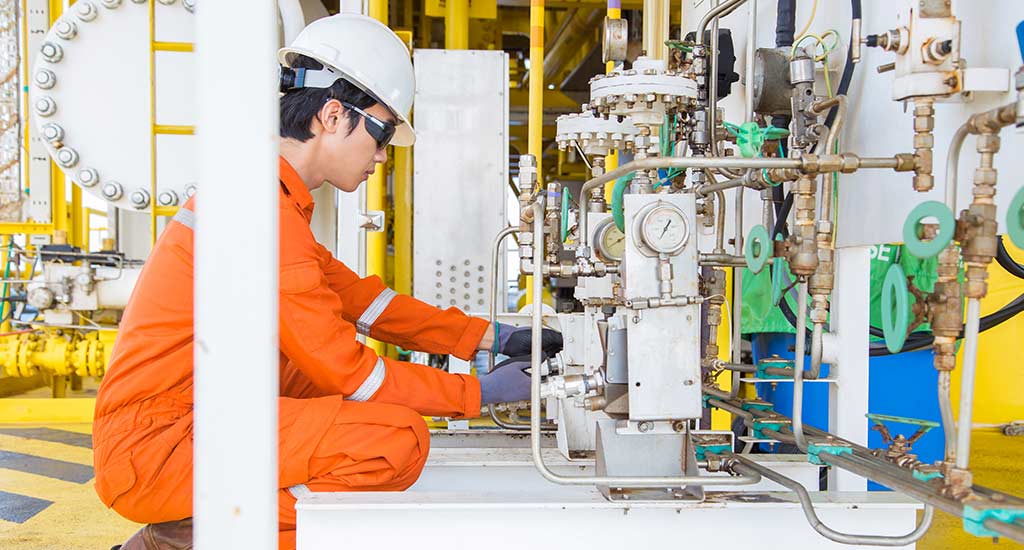 A worker testing the pressure on the tubes of chemical injection control lines